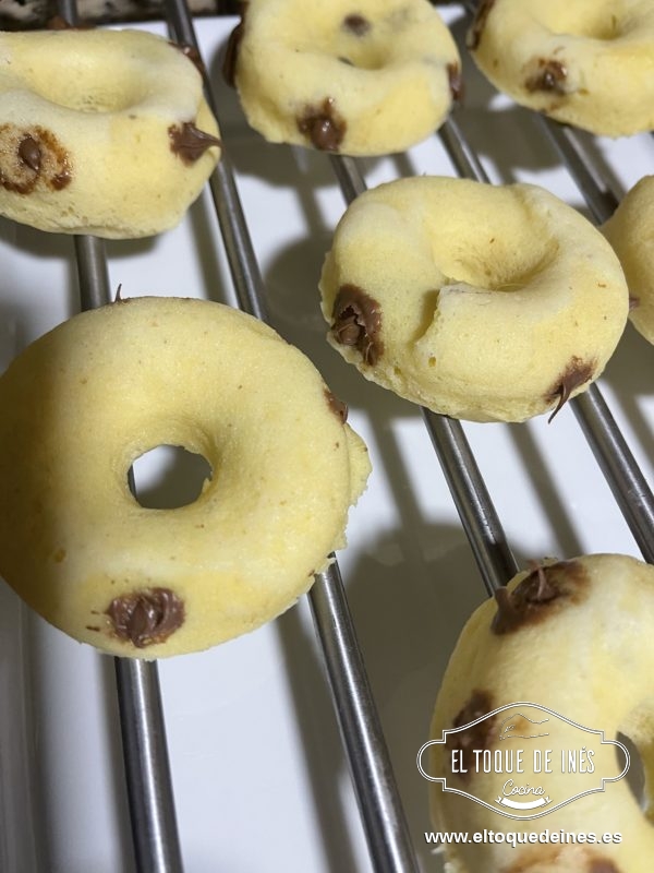 Desmoldamos y con ayuda de una jeringa de repostería pinchamos los donuts y vamos metiendo la crema de cacao, meted en bastantes puntos para que queden más ricos.